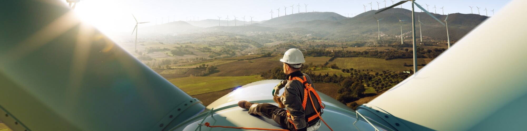 Solar Engineer sat on a wind turbine producing renewable energy for the UK electricity system